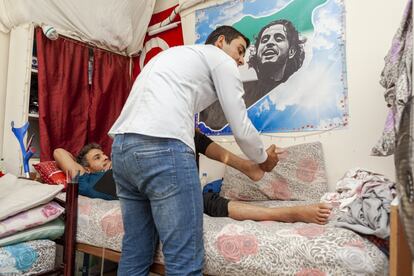 Mahmoud, de 26 años, en una sesión con un fisioterapeuta voluntario en su habitación proporcionada por la ONG Casa para el Bienestar de los Heridos. Era taxista en Homs, Siria, cuando un ataque aéreo en el año 2015 lo dejó en silla de ruedas. Lleva cinco años en esta casa y está a la espera de una operación que no se puede permitir porque cuesta 700 euros. En la pared se observa la imagen de Ibrahim Qashoush, uno de los símbolos de las protestas que empezaron en Siria en 2011 contra el Gobierno de Bashar al Asad.