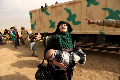 Una mujer huye de los combates entre el Estado Islámico y el ejército iraquí en el distrito de Intisar, al este de Mosul (Irak), hacia un territorio más seguro.
