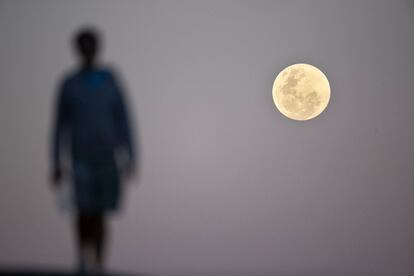 La luna llena se eleva cerca de la playa de Bondi de Sídney antes del eclipse lunar.