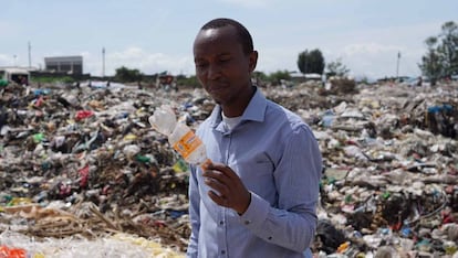 James Wakibia con una botella de plástico encontrada en el vertedero de Gioto, cerca de Nakuru.