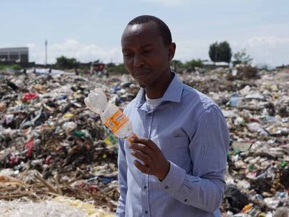 James Wakibia con una botella de plástico encontrada en el vertedero de Gioto, cerca de Nakuru.