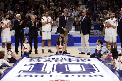 Sergi Llull, Lolo Sainz, Pablo Laso, Felipe Reyes, Rafael Rullán, Sergio Rodríguez, Rudy Fernández y Fernando Romay rodean a Antonio Martín, con la placa conmemorativa en memoria de su hermano Fernando