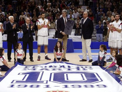 Sergi Llull, Lolo Sainz, Pablo Laso, Felipe Reyes, Rafael Rullán, Sergio Rodríguez, Rudy Fernández y Fernando Romay rodean a Antonio Martín, con la placa conmemorativa en memoria de su hermano Fernando