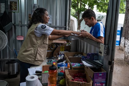 Una voluntaria brinda ayuda a una persona en tránsito, en el Centro de Descanso Temporal Sagrada Familia, un lugar reservado a las familias migrantes y gestionado por Caritas, en la localidad hondureña de Danlì, el 24 de julio de 2024.