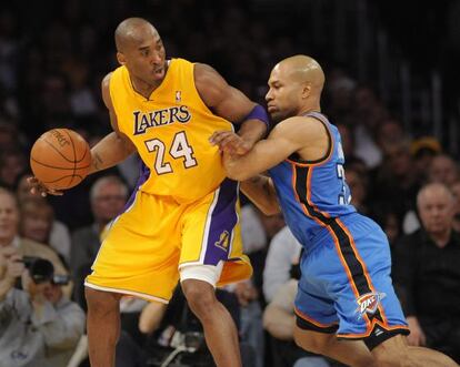 El jugador de los Lakers Kobe Bryant disputa el balón con Derek Fisher