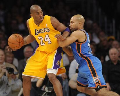 El jugador de los Lakers Kobe Bryant disputa el bal&oacute;n con Derek Fisher 