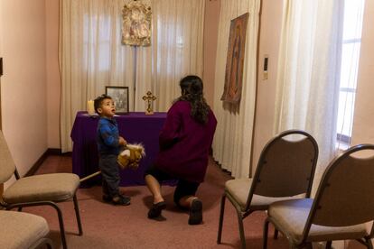 Tabora Garcia y su hijo buscan un momento para rezar frente a un altar en un albergue para migrantes en Tucson, Arizona. 