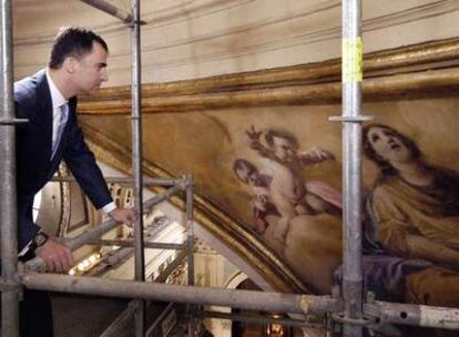 El Príncipe Felipe contempla las obras del pintor de Fuendetodos desde un andamio.