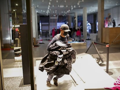 Un manifestante durante el saqueo de una tienda de Barcelona.