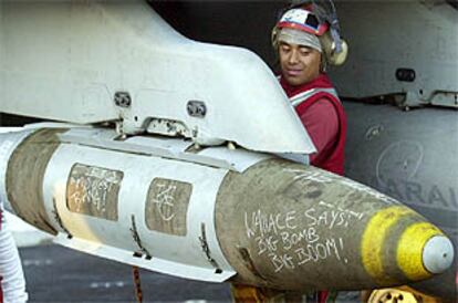 Un marinero del portaaviones estadounidense <i>Theodore Roosevelt</i> coloca un misil en un F-18.