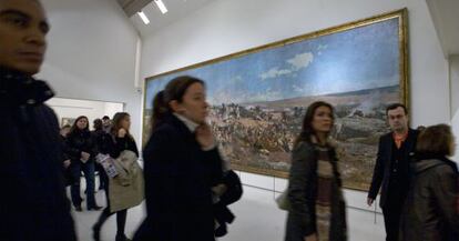 Visitantes pasan por delante de 'La batalla de Tetuán' de Fortuny, en el MNAC.