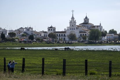 La aldea de El Rocío (Huelva), al fondo, es famosa por la multitudinaria romería del fin de semana del lunes de Pentecostés (este año, el 9 y el 10 de junio), cuando se juntan allí cientos de miles de personas festejando a la Virgen del mismo nombre. Pero también es un núcleo urbano muy pintoresco, sin asfalto y con barandas adonde atar a los caballos, lo que le otorga un aire de poblado del Lejano Oeste (aunque los lugareños digan, con razón, que son los poblados del Oeste los que recuerdan a El Rocío, pues éste existía antes).