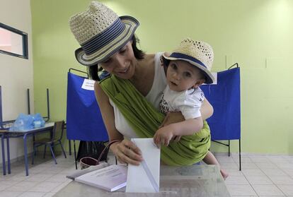 Una mujer vota con su hijo en un colegio electoral en Atenas.