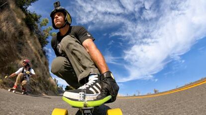 Dos personas hacen skateboard en una carretera mientras se graban con la cámara GoPro Fusion.