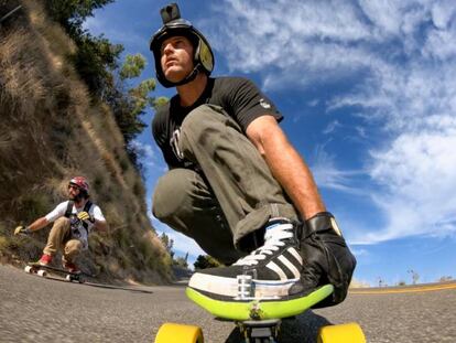 Dos personas hacen skateboard en una carretera mientras se graban con la cámara GoPro Fusion.