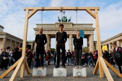 Activistas realizan una acción reivindicativa contra el cambio climático frente a la Puerta de Brandenburgo en Berlín durante la protesta de hoy. 