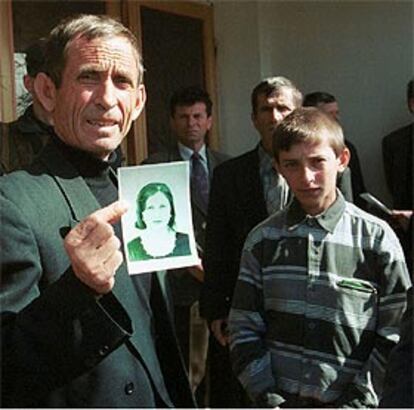 El padre de la joven asesinada muestra una foto de su hija.