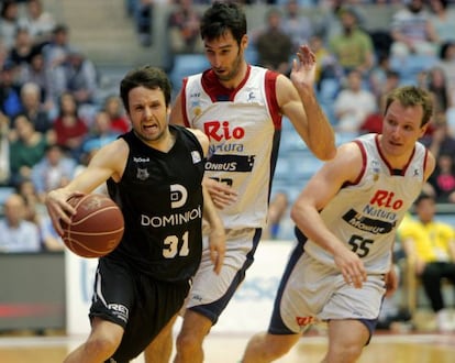 Raul López protege un balón del acoso de los jugadores del Obradoiro, Alberto Corbacho y Rafa Luz.