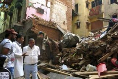 Unos hombres hablan frente a las ruinas de un antiguo edificio que se colapsó el 9 de octubre en la parte vieja de la ciudad.