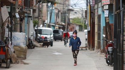 Una mujer con mascarilla camina por Villa 31 en Buenos Aires, Argentina.