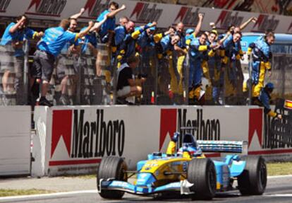 Fernando Alonso y los operarios de su equipo, el Renault, alzan los brazos para celebrar su segundo puesto.