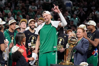 Kristaps Porzingis, el pívot de los Celtics, levanta el brazo mientras celebra la victoria con el resto de compañeros.