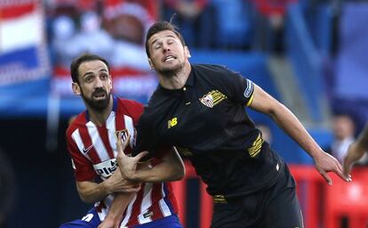 Juanfran agarra a Krychowiak durante el partido entre Atlético y Sevilla en el Calderón.