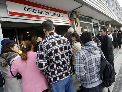 Desempleados hacen cola a las puertas de una oficina madrileña de empleo.