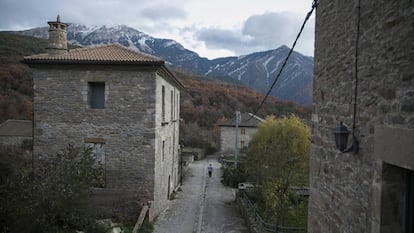 Una mujer camina por la calle principal de Nocito (Huesca).