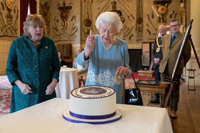 La reina Isabel II corta una tarta el pasado sábado durante la recepción que organizó en su residencia de Sandringham, y que marca el inicio de las celebraciones del Jubileo de Platino, que terminarán con un puente de cuatro días previsto para junio.