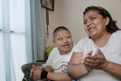 Asela Guadalupe López charla con su hijo Víctor en el salón de su casa.