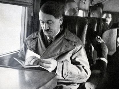 Adolf Hitler, líder del partido nazi, leyendo en el interior de un avión.