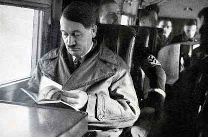 Adolf Hitler, líder del partido nazi, leyendo en el interior de un avión.