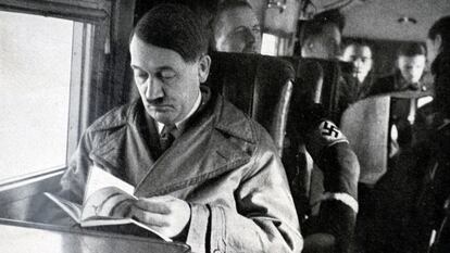 Adolf Hitler, líder del partido nazi, leyendo en el interior de un avión.