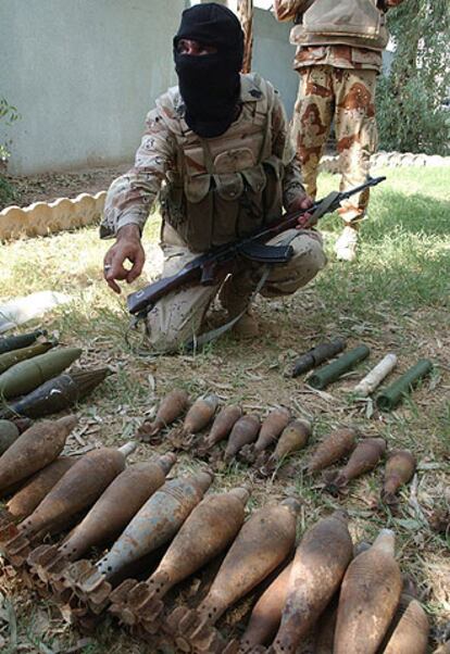Un soldado iraquí muestra las armas entregadas por los milicianos.