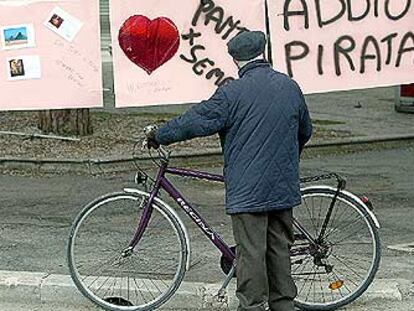 Un viejo ciclista se detiene ante carteles de recuerdo a Pantani en su ciudad, Cesenatico.