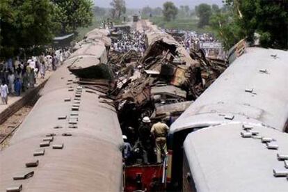 Miembros de los equipos de rescate inspeccionan los trenes que colisionaron en Ghotki.