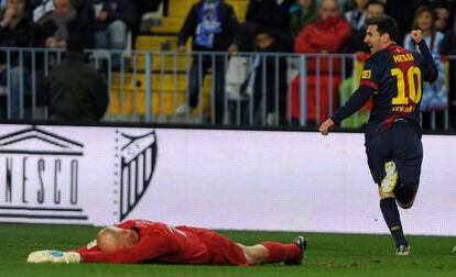 Barcelona&#039;s Lionel Messi celebrates after scoring against Malaga&#039;s goalkeeper Willy Caballero.