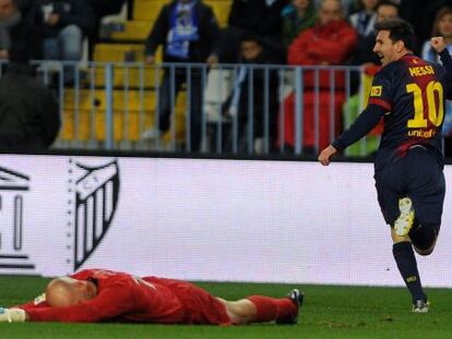 Barcelona&#039;s Lionel Messi celebrates after scoring against Malaga&#039;s goalkeeper Willy Caballero.