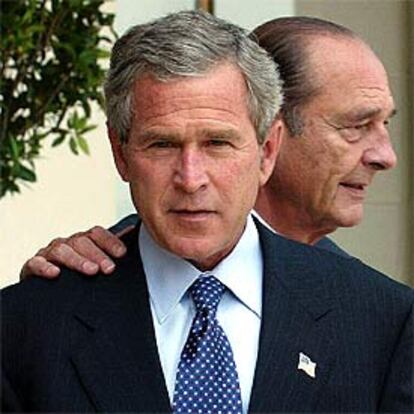 Jacques Chirac posa su mano sobre el hombro de George W. Bush durante su encuentro, ayer, en Evian.