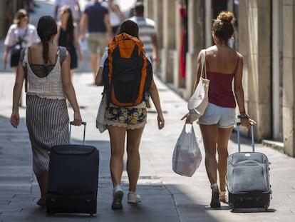 Tres turistas con sus maletas en Barcelona. 