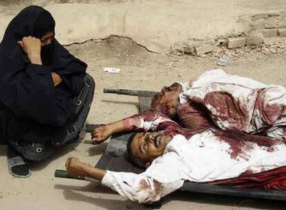 Una mujer, ante los cadáveres de dos familiares secuestrados y asesinados ayer en Bagdad.