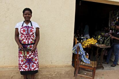 Una alumna posa con un delantal de la tienda de Irembo en frente de la primera tienda abierta en Kigali.