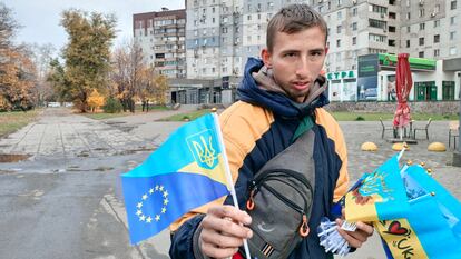 Un joven vende banderas de la UE y de Ucrania frente al edificio en el que creció Volodímir Zelenski en Krivii Rih.