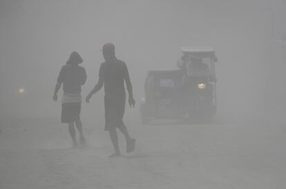 Los residentes caminan entre una nube de cenizas mientras el volcán Taal continuaba arrojando cenizas el lunes 13 de enero, en Lemery, provincia de Batangas. El volcán, que ha entrado en erupción 33 veces desde 1572, causó unos 1.300 muertos en una erupción en 1911 y 200 en 1965.