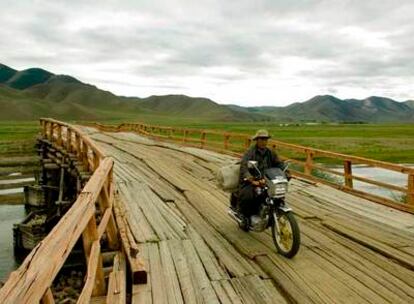 Un motorista cruza el río Ider por el destartalado puente de Jargalant, en el centro de Mongolia.