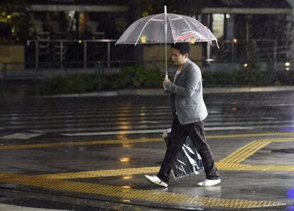 Un viandante camina bajo una intensa lluvia en el centro de Tokio. Se prevé que el Vongfong, que podría ser el tifón más fuerte que golpea Japón este año, llegue a la capital japonesa durante la madrugada de este martes.