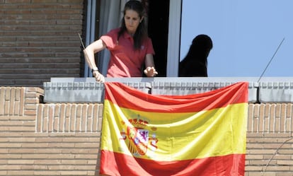 La infanta Elena coloca la bandera española en su casa.