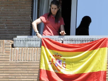 La infanta Elena coloca la bandera española en su casa.