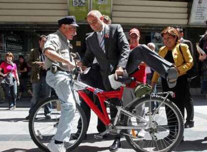 Miguel Sebastián se monta en una bici durante su paseo por el centro de la capital.